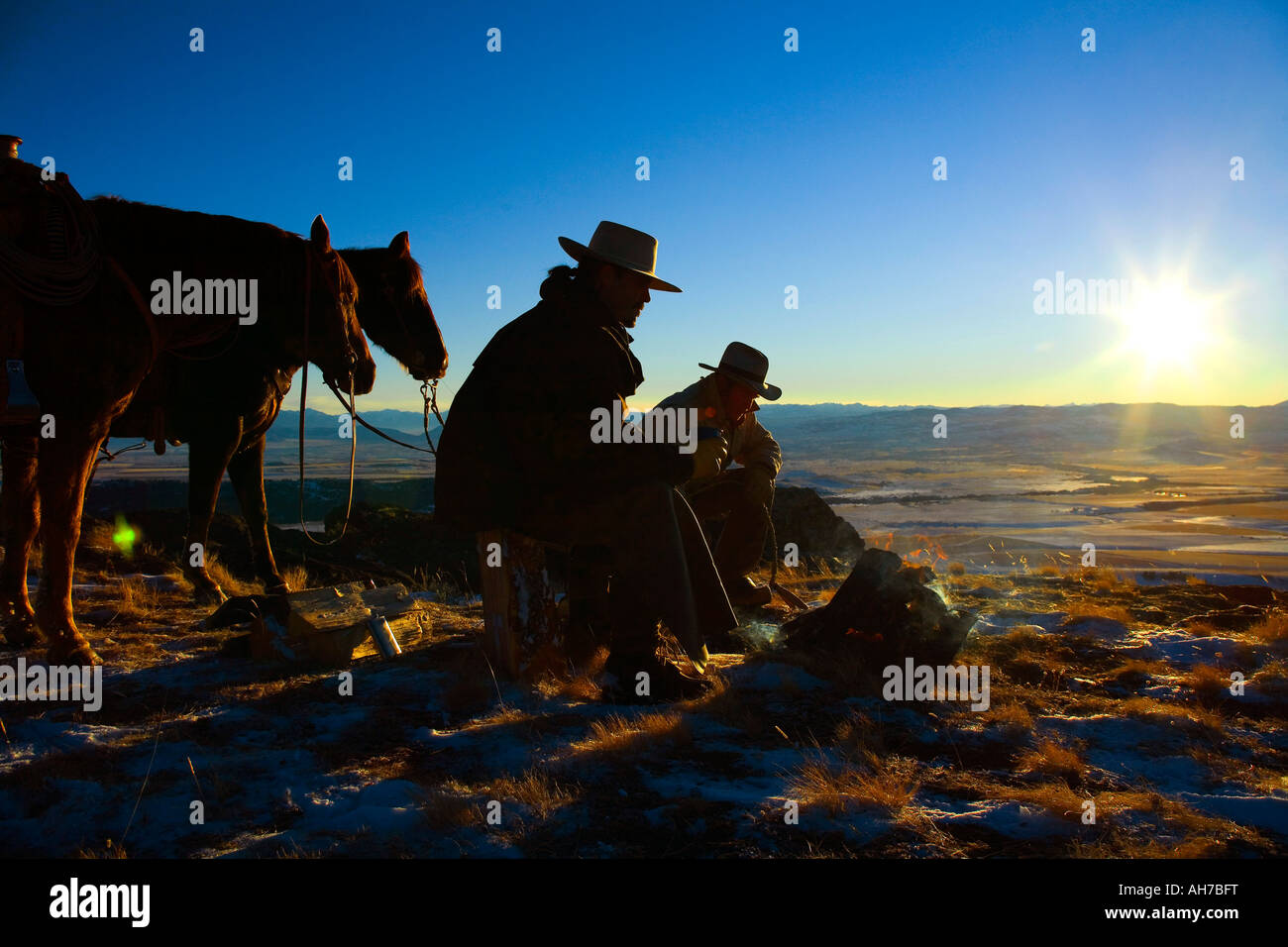 Due uomini seduti davanti a un falò Foto Stock