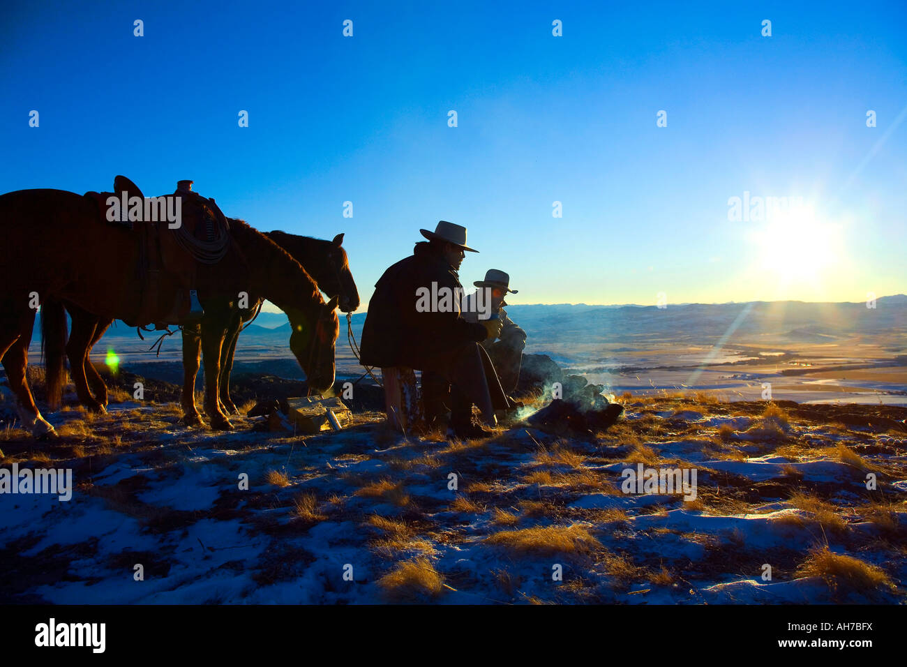 Due uomini seduti davanti a un falò Foto Stock
