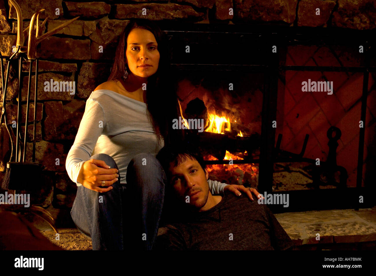 Giovane donna e una metà uomo adulto seduto davanti a un incendio Foto Stock