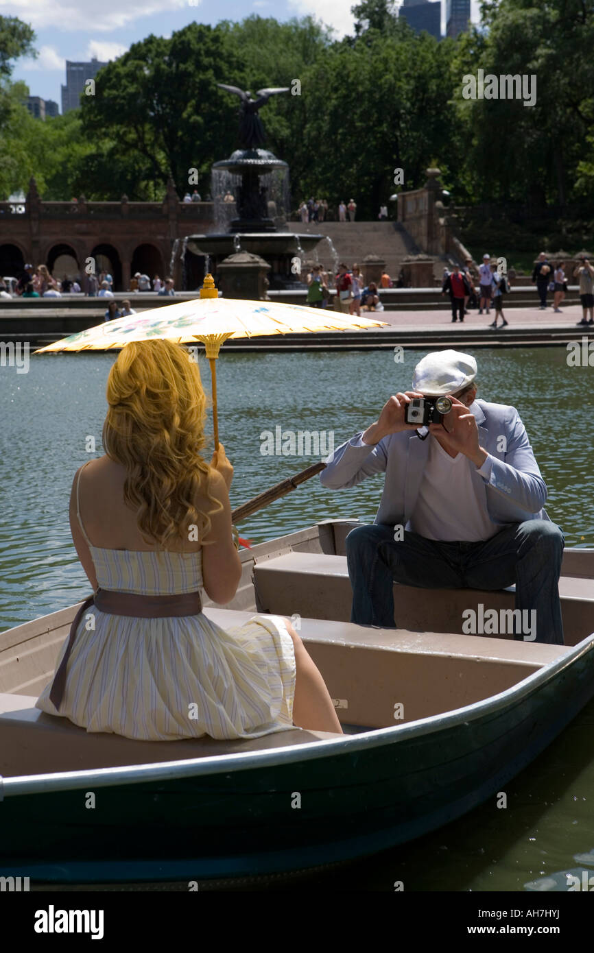 Giovane uomo di scattare una foto di una giovane donna seduta su una barca, Central Park, Manhattan, New York, New York, Stati Uniti d'America Foto Stock