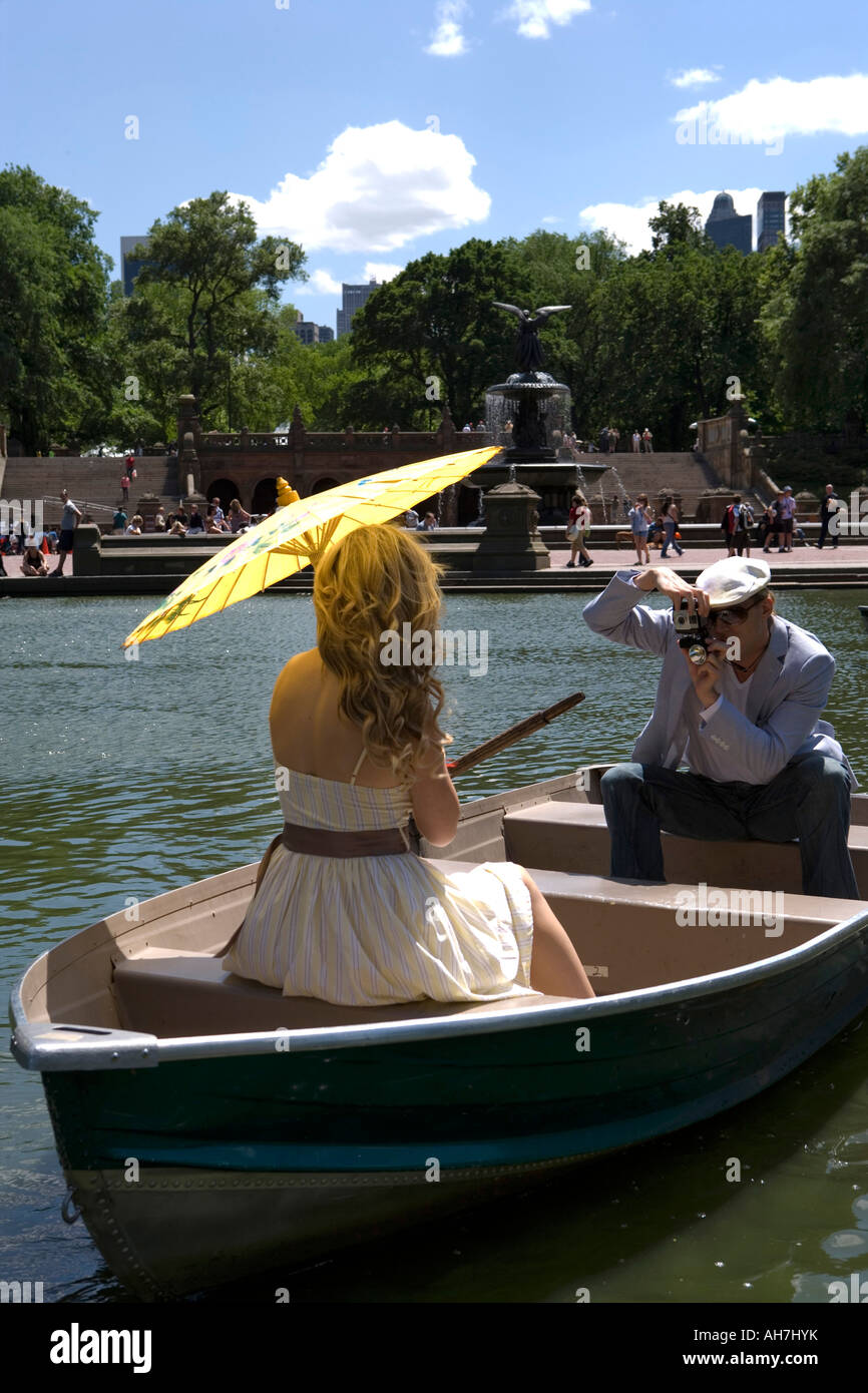 Giovane uomo di scattare una foto di una giovane donna seduta su una barca, Central Park, Manhattan, New York, New York, Stati Uniti d'America Foto Stock