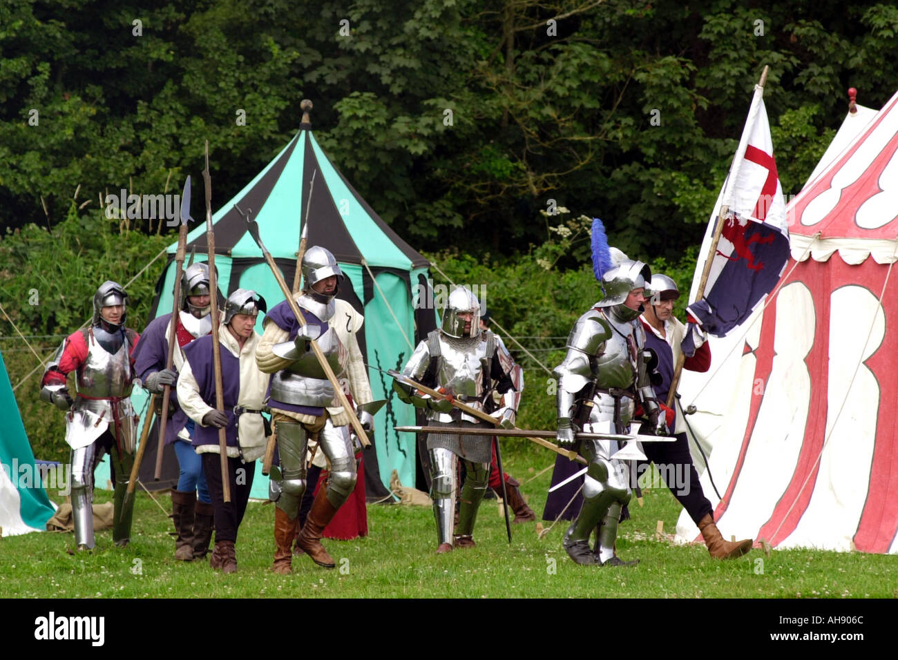 Cavalieri in armatura marzo da accampamento presso re emanazione di una battaglia medievale a Cosmeston Borgo Medievale South Wales UK GB Foto Stock