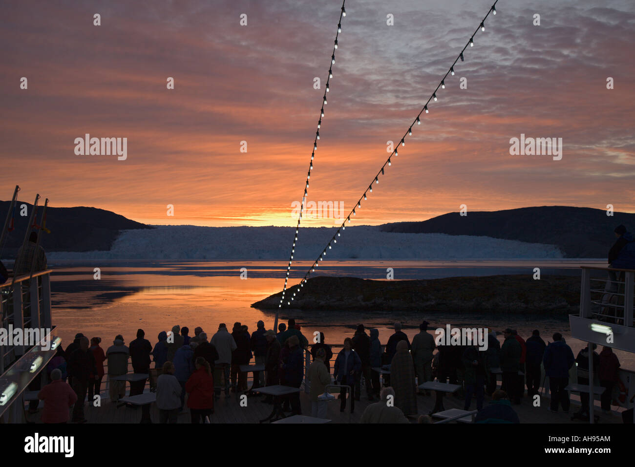 Stagliano passeggeri su una nave da crociera la vista spettacolare ghiacciaio Eqip presso sunrise a Disko Bay sulla costa occidentale della Groenlandia Foto Stock