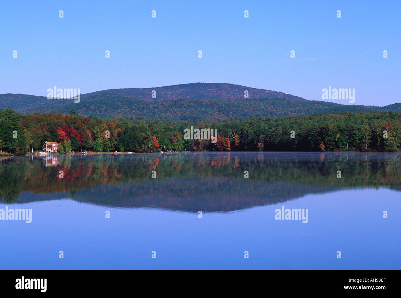 Autunno colline riflessa in un lago, New Hampshire Foto Stock