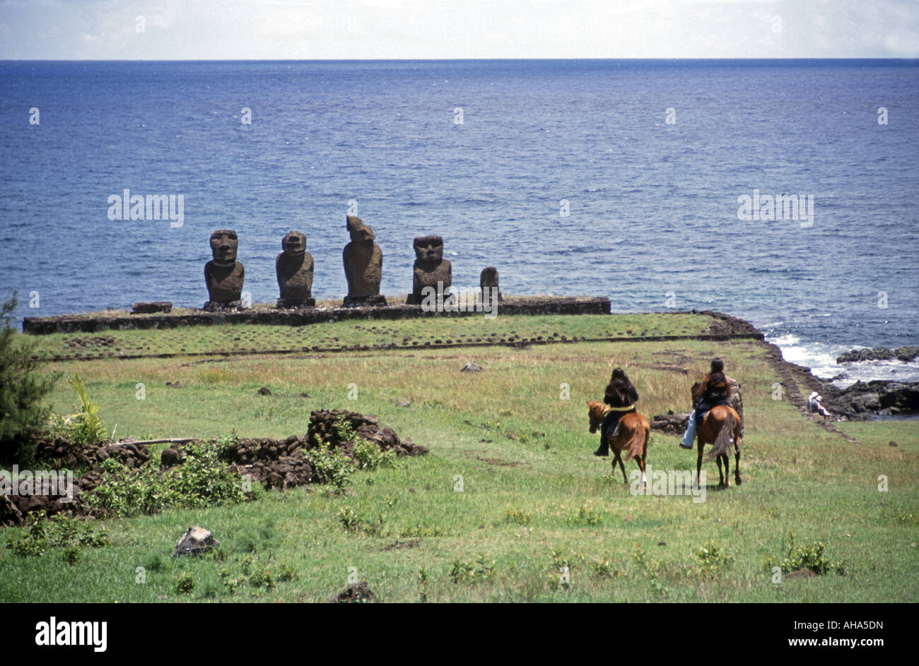 Cavalieri locali a Tahai, Isola di Pasqua, Cile, Sud Pacifico con AHU Vai Ure in background Foto Stock