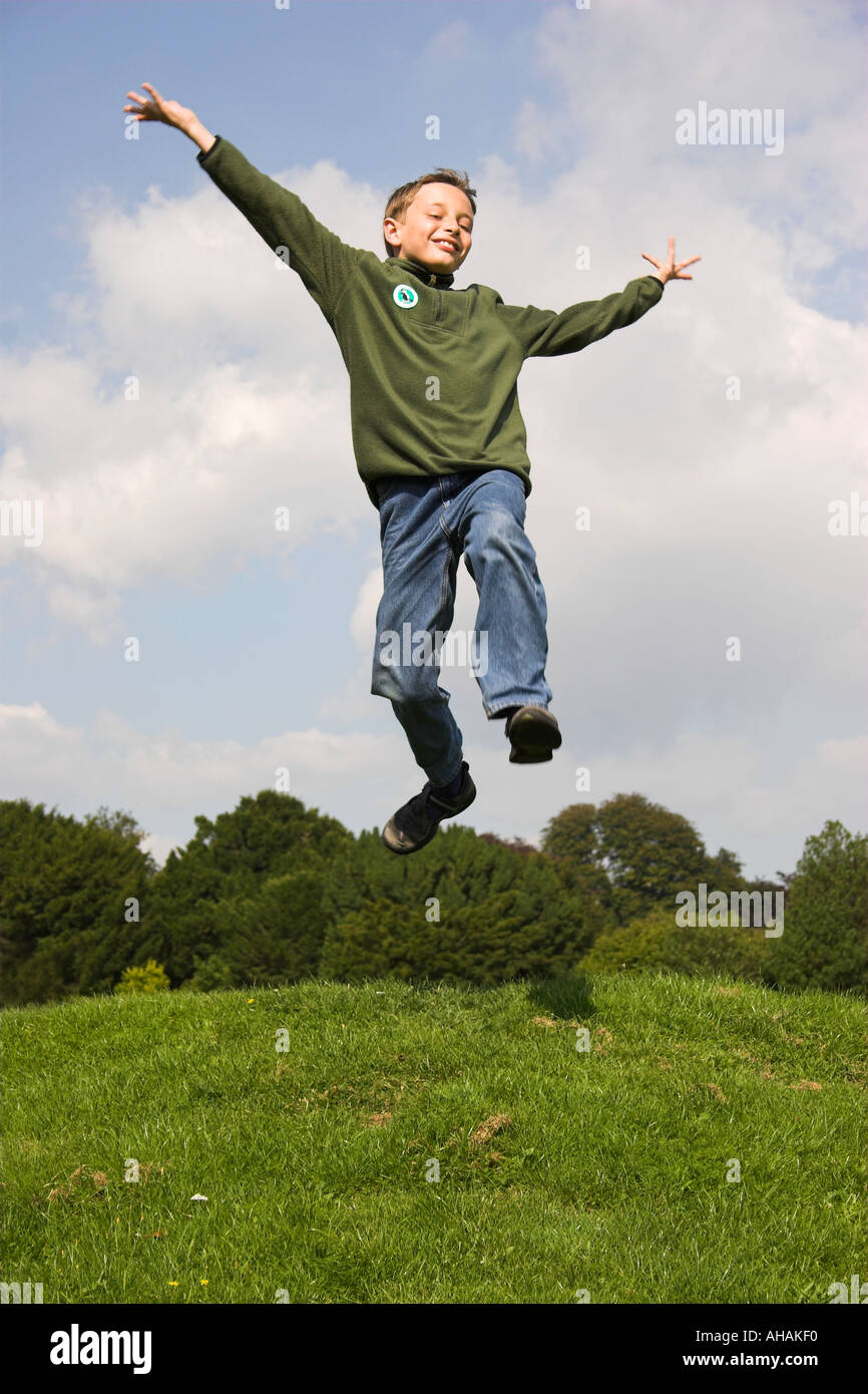 Dieci anni di old boy jumping braccia ampia. Foto Stock