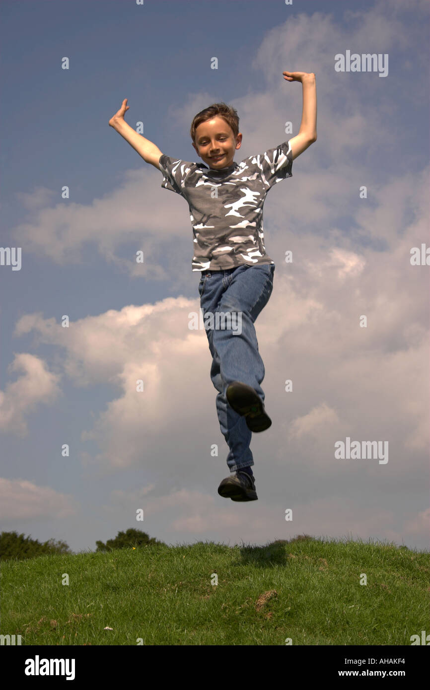 Dieci anni di old boy jumping ruotando ed estraendo una sorpresa di fronte. Foto Stock