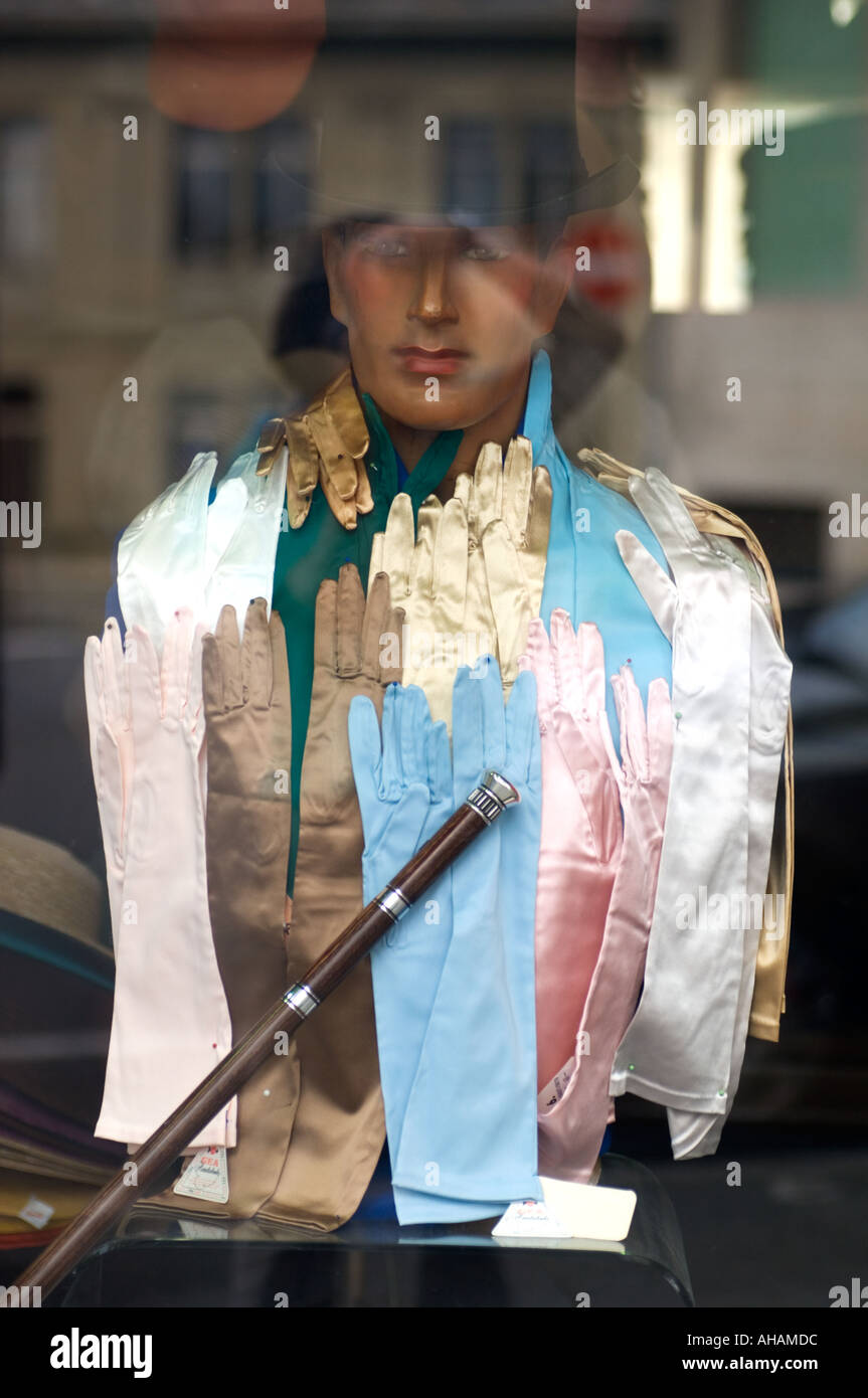 La finestra di visualizzazione di un busto manichino di un uomo coperto con piena lunghezza pastello guanti di seta che indossa un cappello a cilindro con un bastone da passeggio Foto Stock