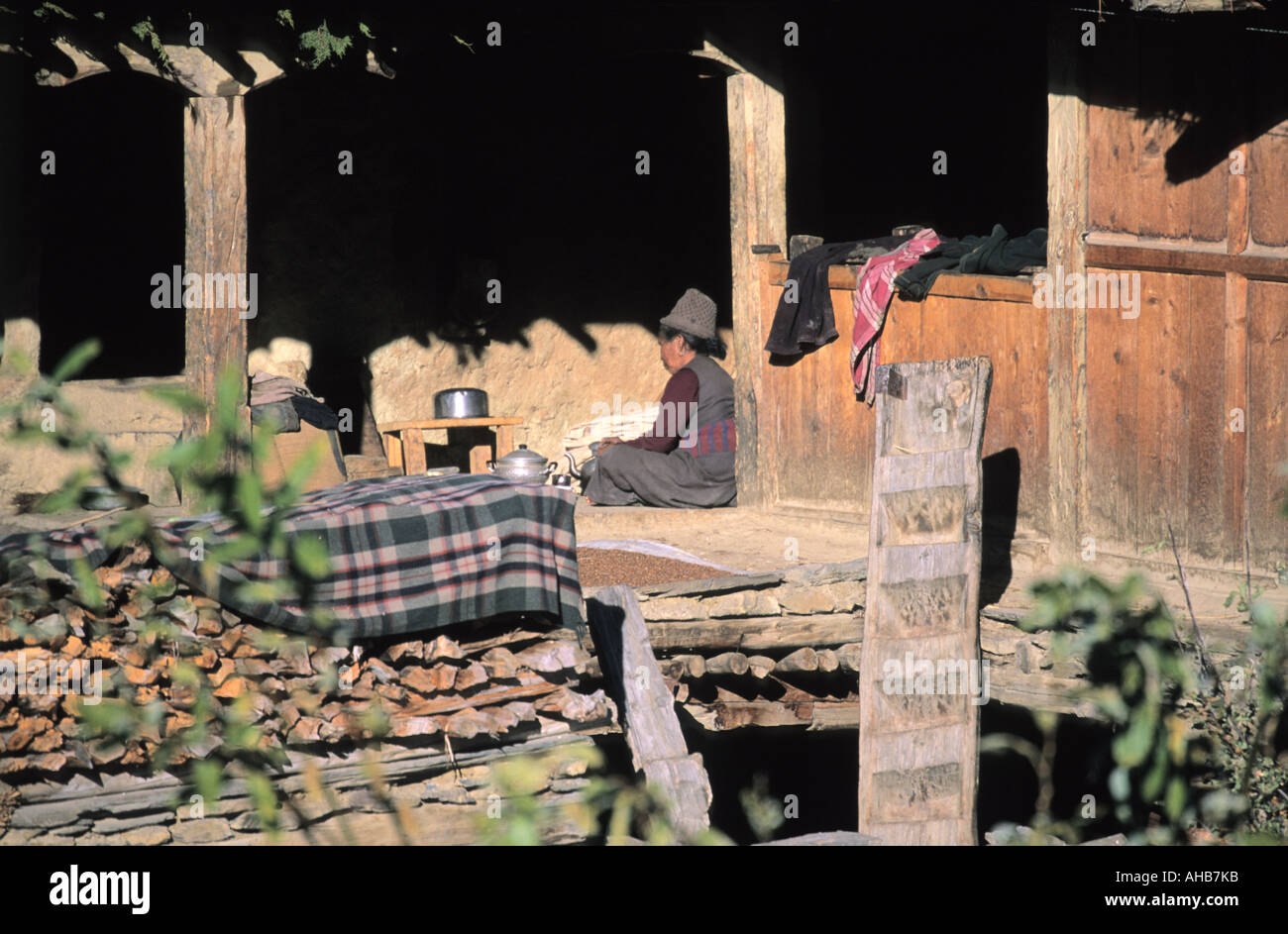 Donna nepalese prepara il cibo sul secondo livello del cortile nel villaggio Ngawal Annapurna conservation area Nepal Foto Stock