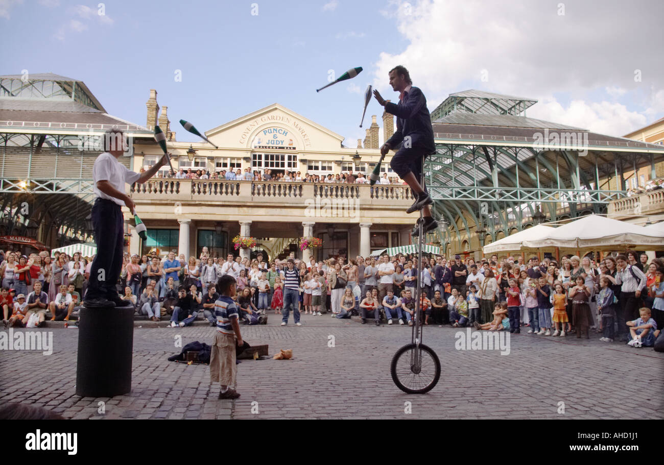 Artisti di strada giocoleria sul monociclo a Covent Garden di Londra al di fuori di Punch e Judy pub Foto Stock