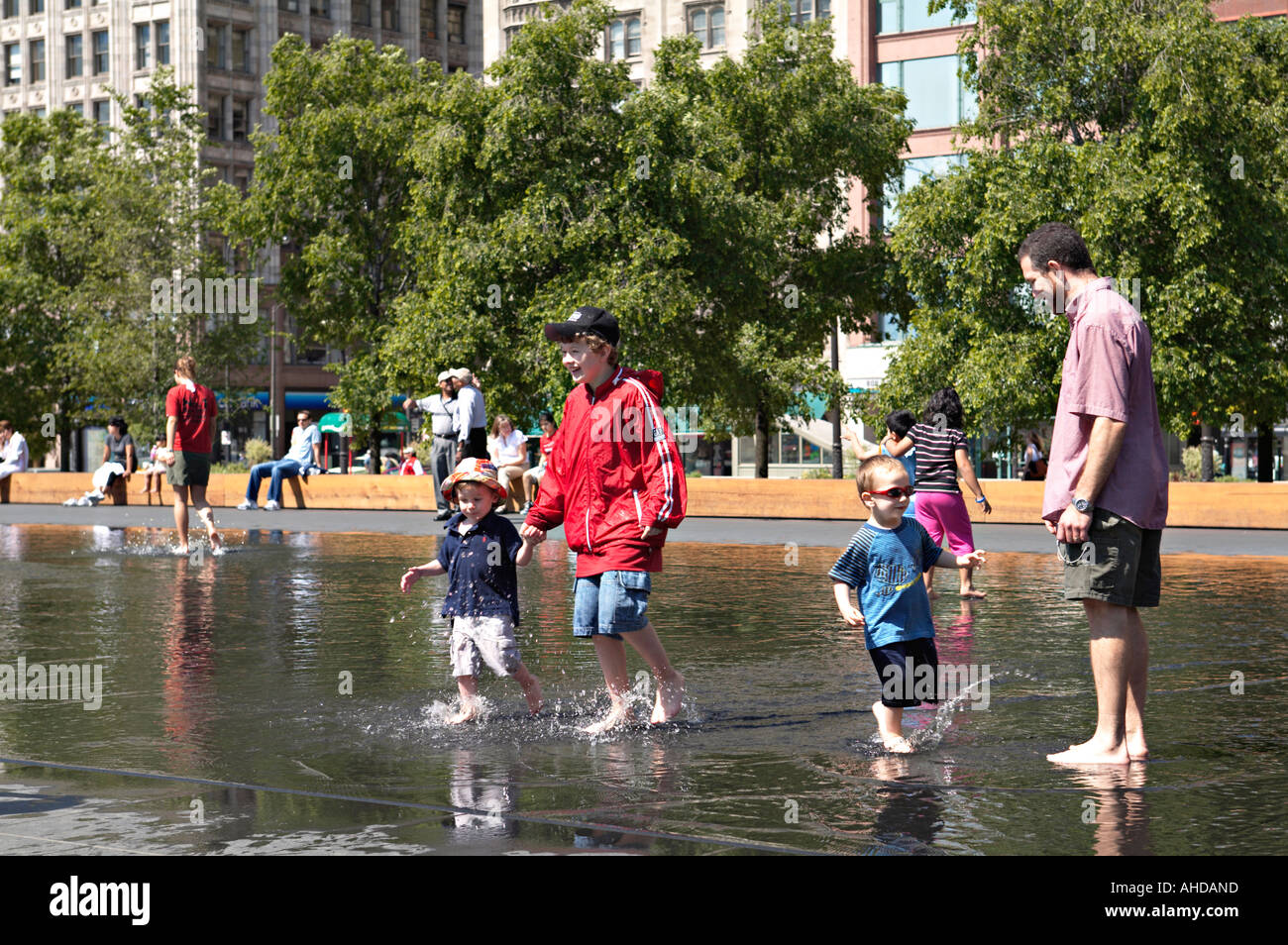 ILLINOIS Chicago persone giocare in acqua della corona Fontana nel Millennium Park bambini e adulti Foto Stock