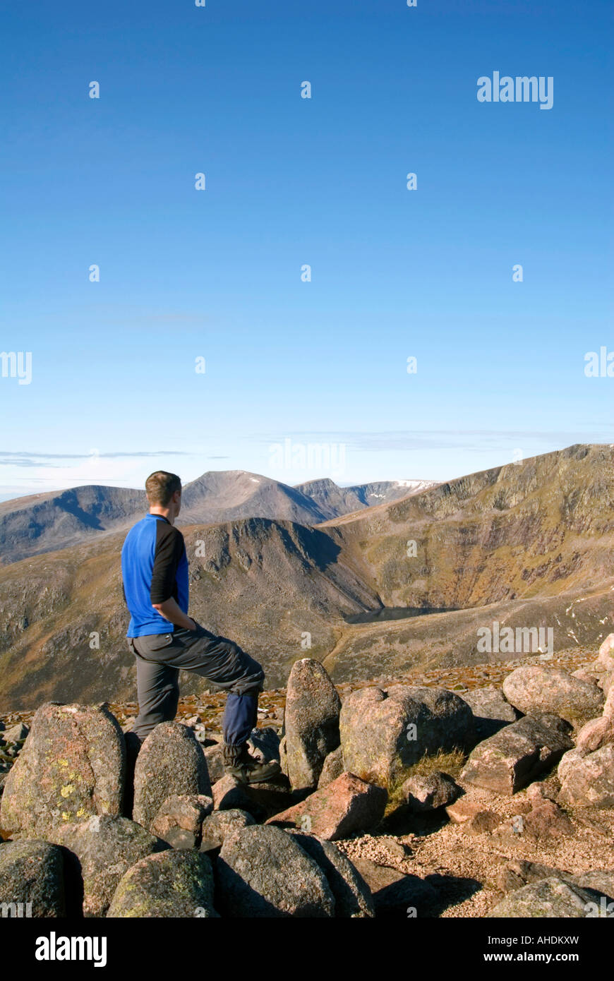 Una collina-walker guarda di fronte a Lochan Uaine e Ben Macdui dal vertice di Derry Cairngorm. Foto Stock