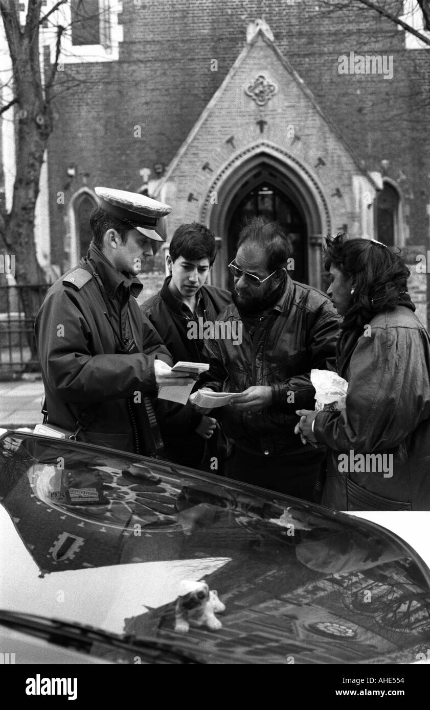 Un vigile spiega parcheggio regolamenti per i membri del pubblico a lamentarsi per ricevere i biglietti per il parcheggio, Londra, Regno Unito. Foto Stock