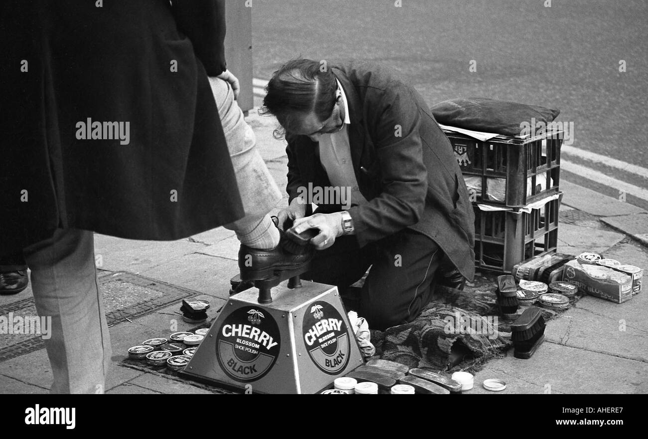 Lustrascarpe Boy in azione in via della città Foto Stock