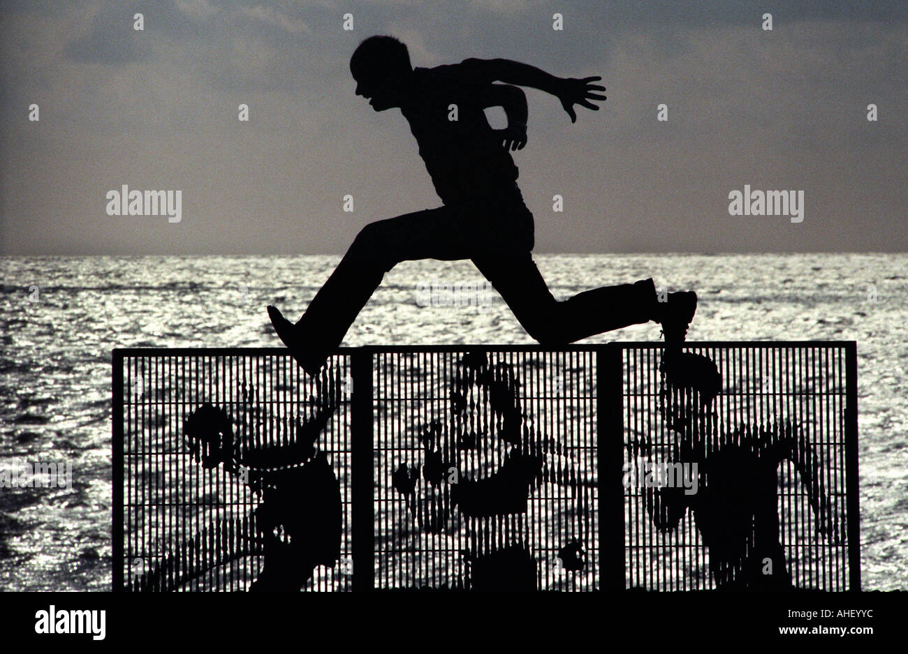 Scultore Bruce Williams salta su tre del suo taglio laser pannelli di recinzione per un progetto di arte pubblica denominata parete in esecuzione Foto Stock