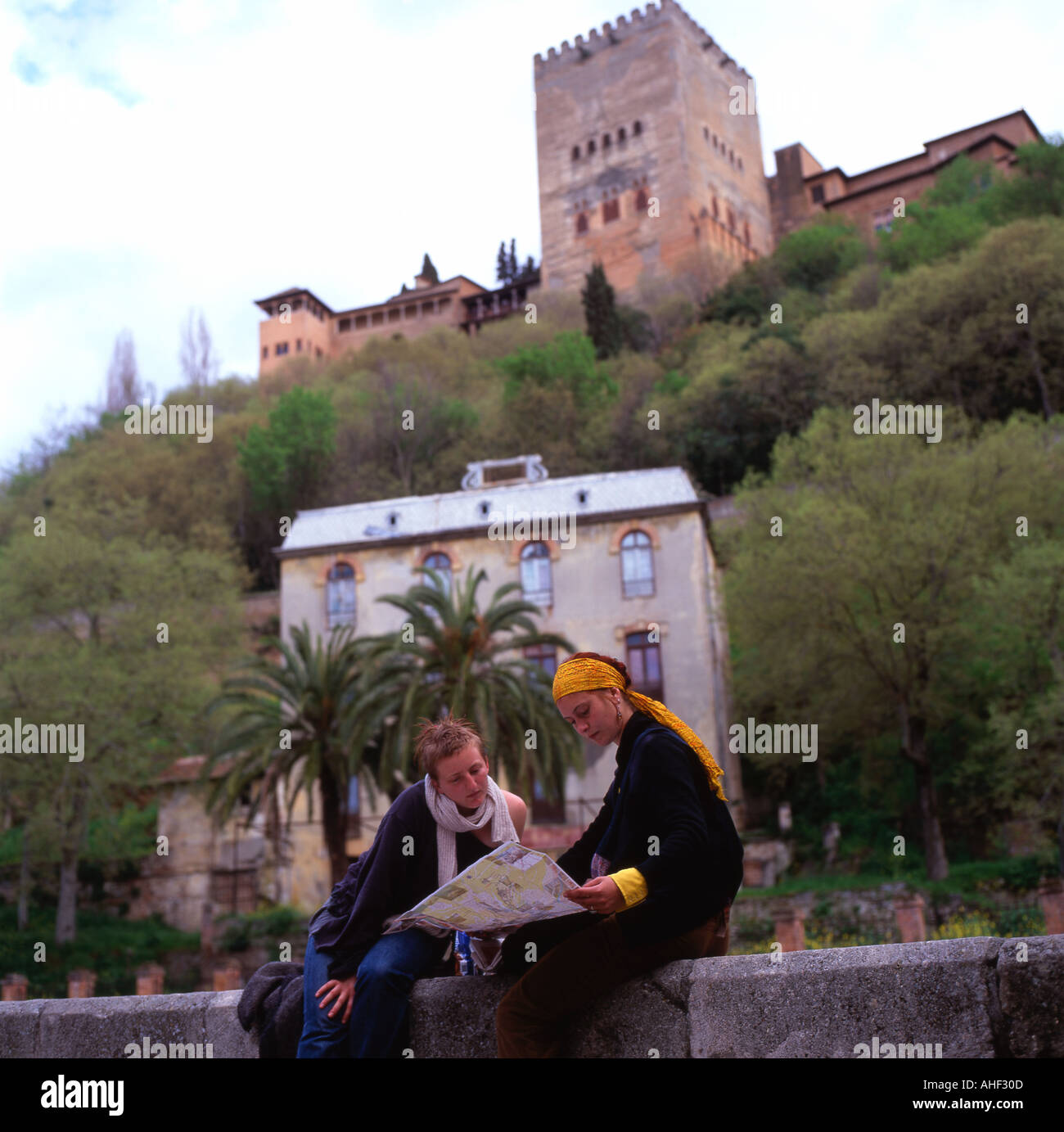 Donne in viaggio alla ricerca di una mappa con una vista della Alhambra Palace in background in Granada Andalusia Spagna meridionale KATHY DEWITT Foto Stock