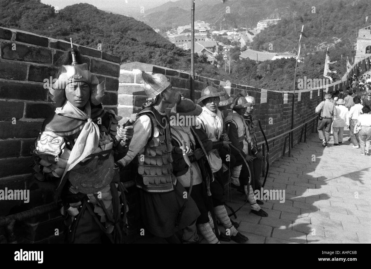 Un personale vestito come guardie prendere un periodo di riposo come turista in visita a piedi passato essi sulla Grande Muraglia Cinese. Foto Stock