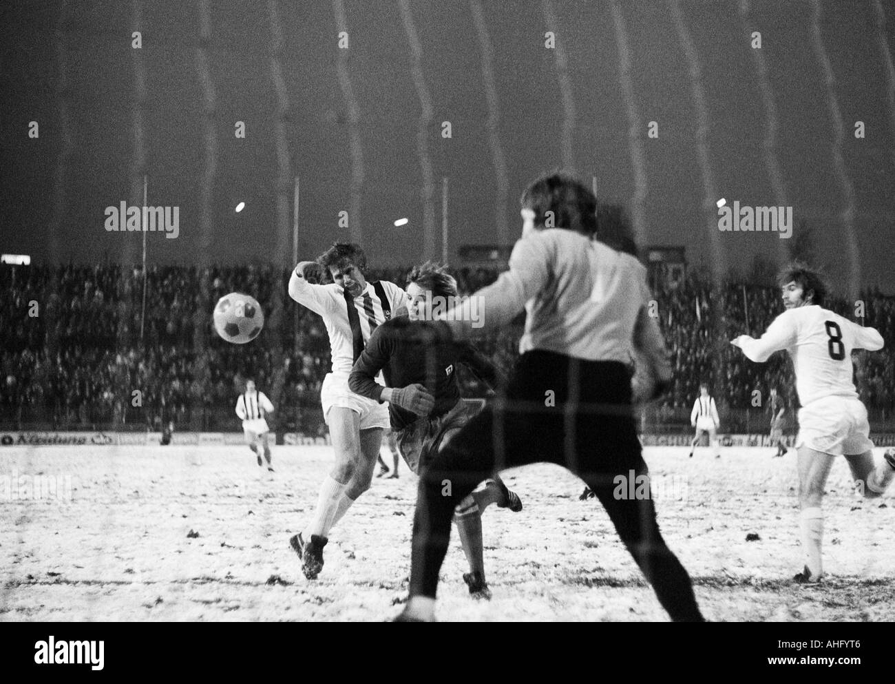 Calcio, DFB Cup, ottavo di finale, 1973/1974, Borussia Moenchengladbach contro Hamburger SV 2:2 dopo un tempo supplementare, Boekelberg Stadium di Moenchengladbach, gioco sulla neve suolo, scena del match, f.l.t.r. Jupp Heynckes (MG), Manfred Kaltz (HSV) coperta, mantenere Foto Stock