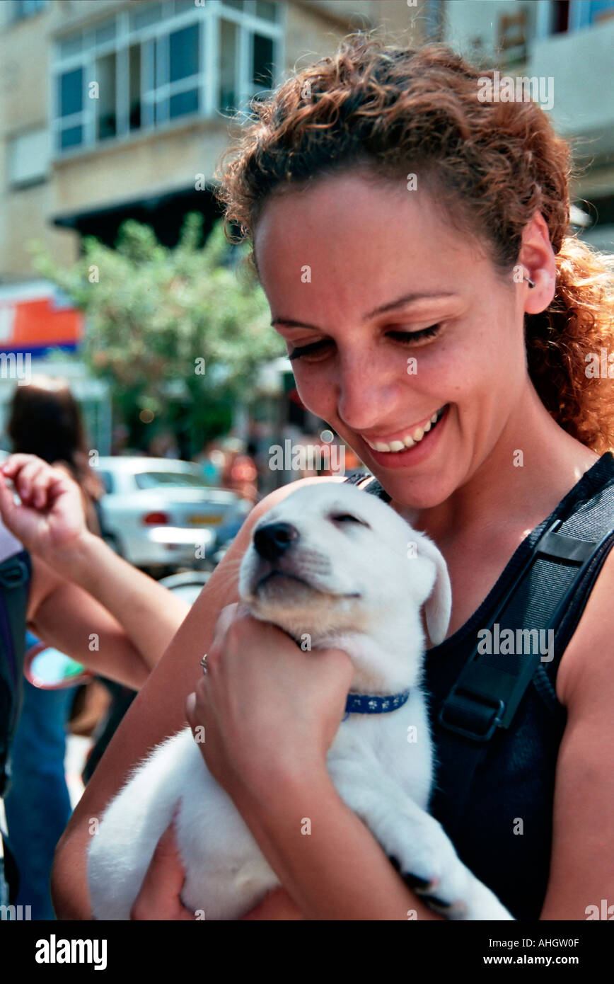 Israele Tel Aviv una donna che guarda affettuosamente a un giovane cucciolo Foto Stock