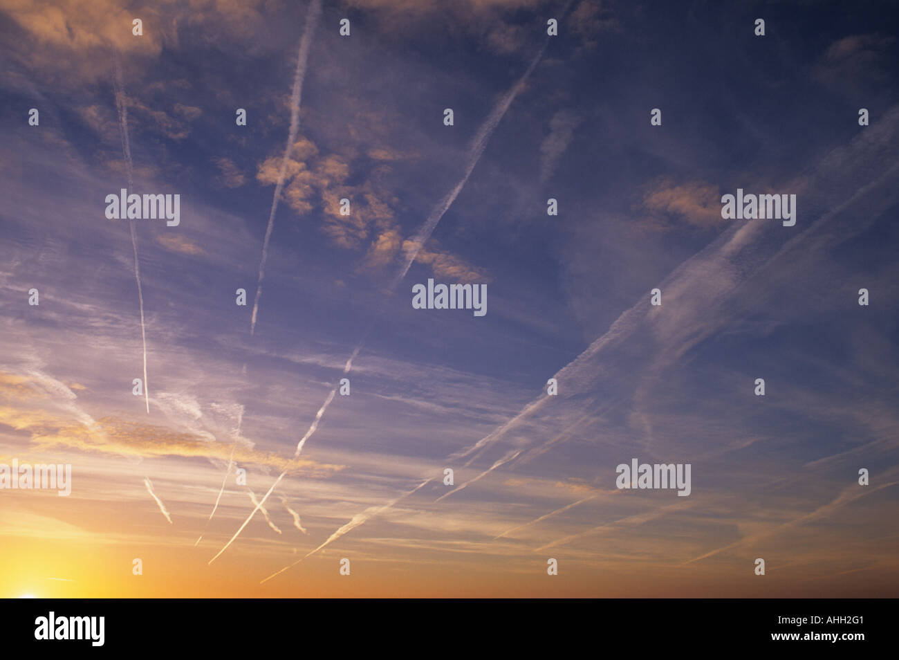 Aeroplano sentieri di vapore al sorgere del sole, attraversando la vasta cieli del Lincolnshire, Regno Unito. Foto Stock
