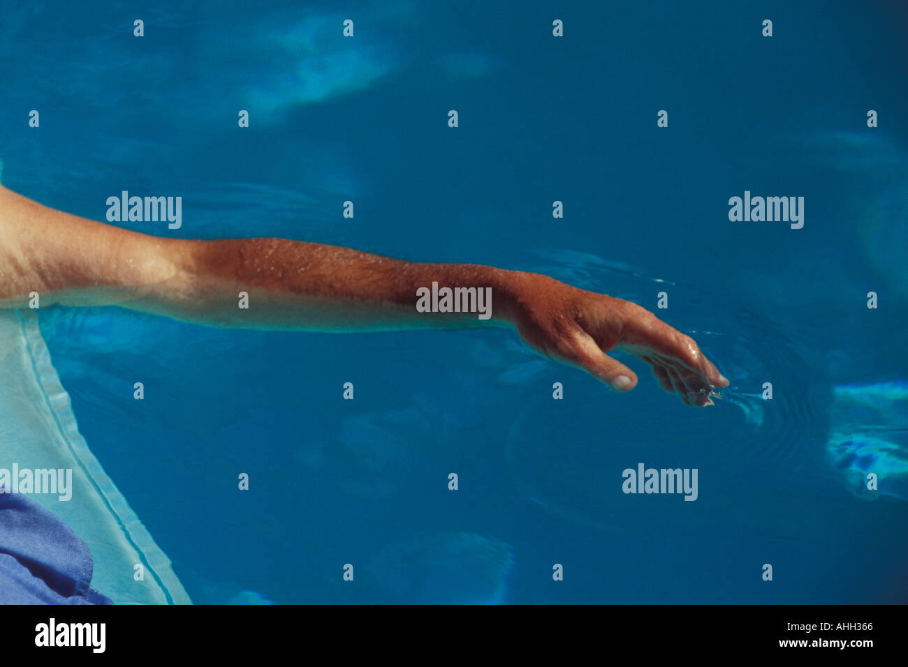 L'uomo sul materasso ad aria galleggianti in piscina il braccio e la mano Foto Stock