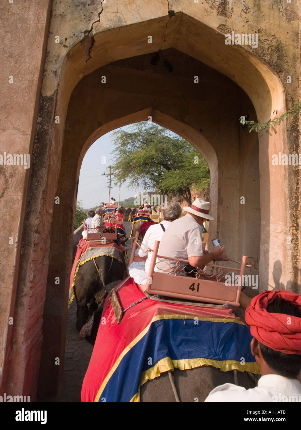 I turisti equitazione elefante taxi tramite gateway a Forte Amber dalla sede di elefante guardando sopra mahout il turbante rosso. Jaipur Foto Stock