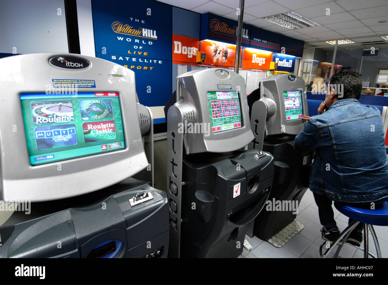 Persone a giocare alla roulette su fixed odds i terminali scommessa a William Hill bookmakers, England, Regno Unito Foto Stock