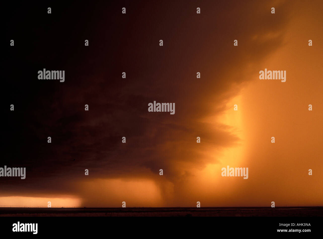 USA Texas Friona polvere arancione e l'impostazione colore sun massiccia cumulonimbus supercell storm cloud su terreni agricoli Foto Stock