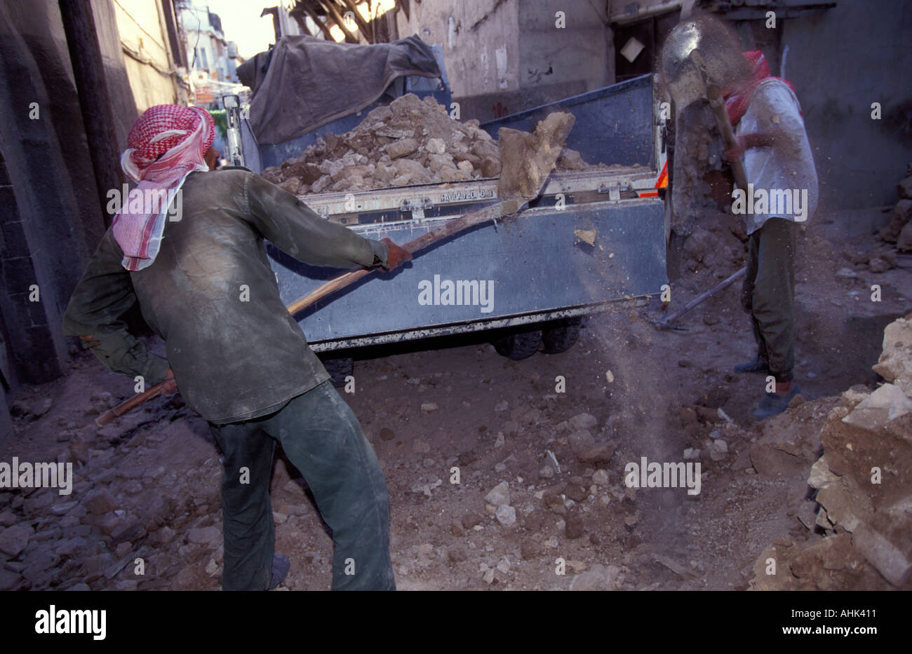 Costruzione di lavoratori il caricamento di carrello con pietrisco a Damasco in Siria Foto Stock