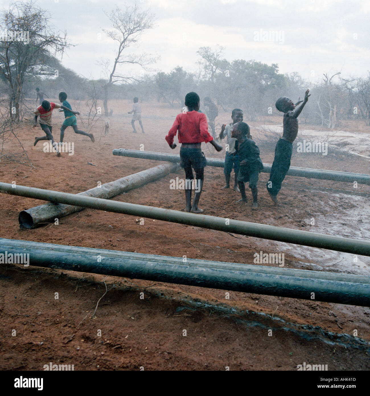 Scuola di ballo per bambini con entusiasmo come un impianto di perforazione urta contro acqua sicura in colpite dalla siccità Transvaal in Sud Africa. Foto Stock