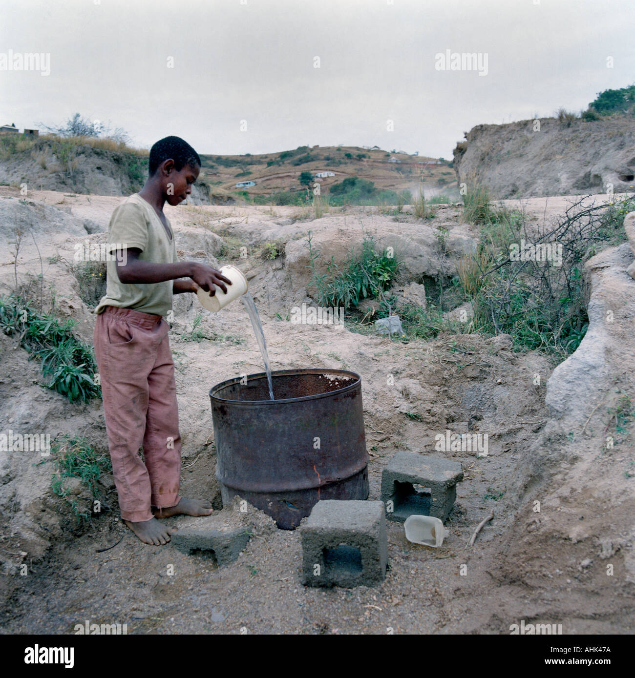 Bambino la raccolta di acqua da un pericoloso materie alimentazione nel Transvaal in Sud Africa, a rischio di contaminazione e di malattia. Foto Stock