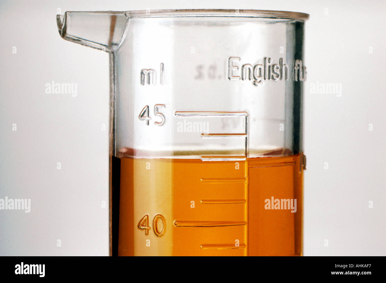 Cilindro graduato con liquido arancione close up Foto Stock