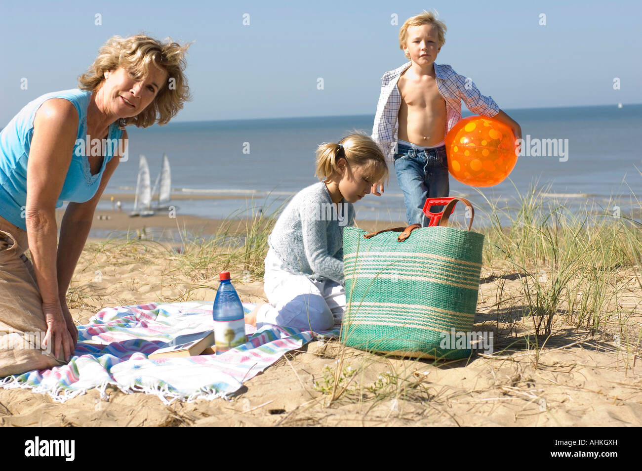 Nonna e nipoti avente picnic sulla spiaggia Foto Stock