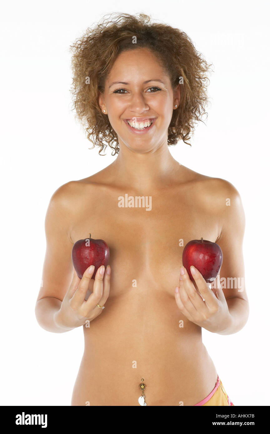 Razza mista donna tenendo le mele rosse a coprire i seni Foto Stock