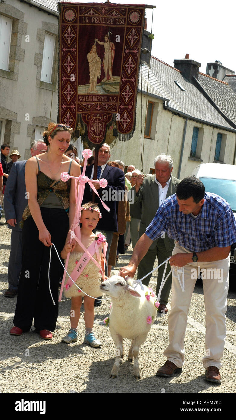 Una stanca piccolo ragazzo con sua madre, nonno e pecore nel villaggio processione annuale di perdono, festival religioso Foto Stock