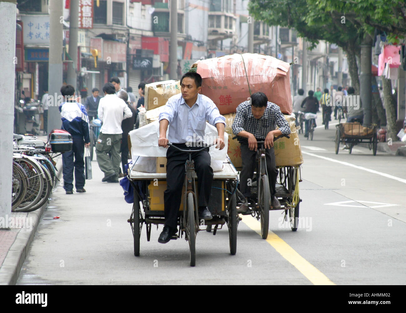 Ciclisti in risciò che trasportano merci in una speciale pista ciclabile a Shanghai, Cina Foto Stock