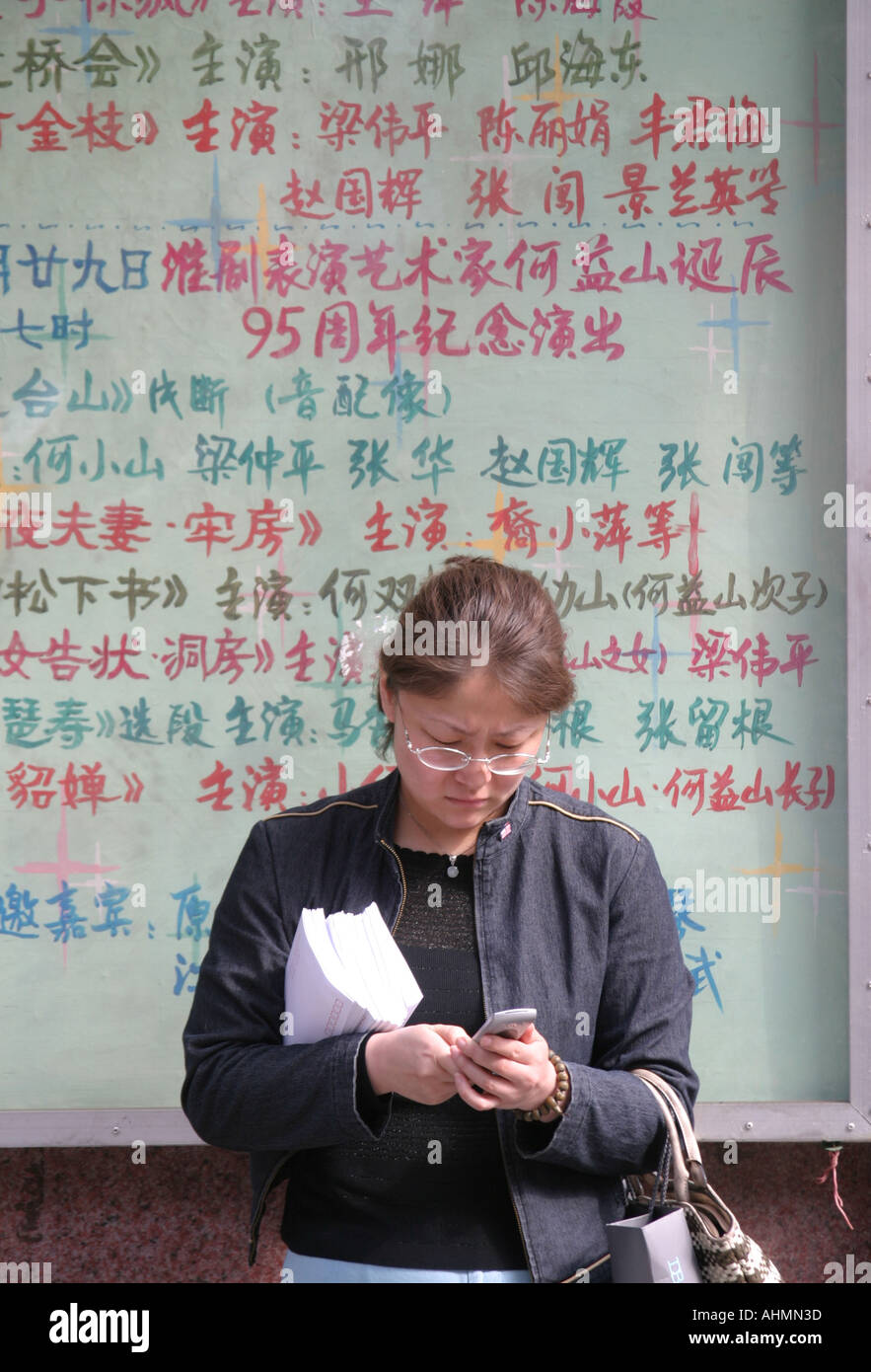 Donna che controlla il suo cellulare a Shanghai, Cina Foto Stock