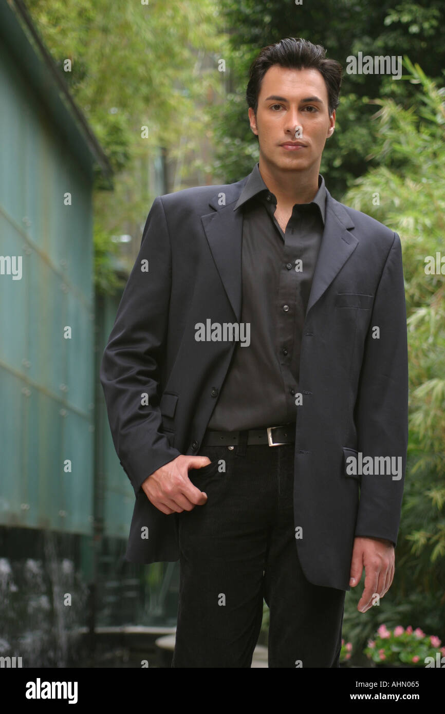 Tall dark uomo bello in business suit in città giardino Foto Stock