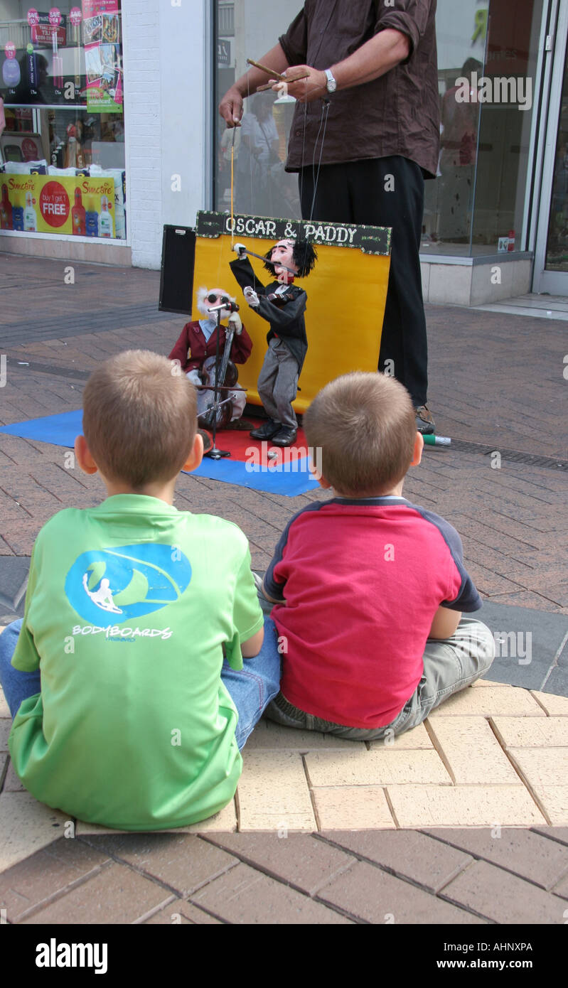 I bambini a guardare uno spettacolo di burattini in centro commerciale Foto Stock