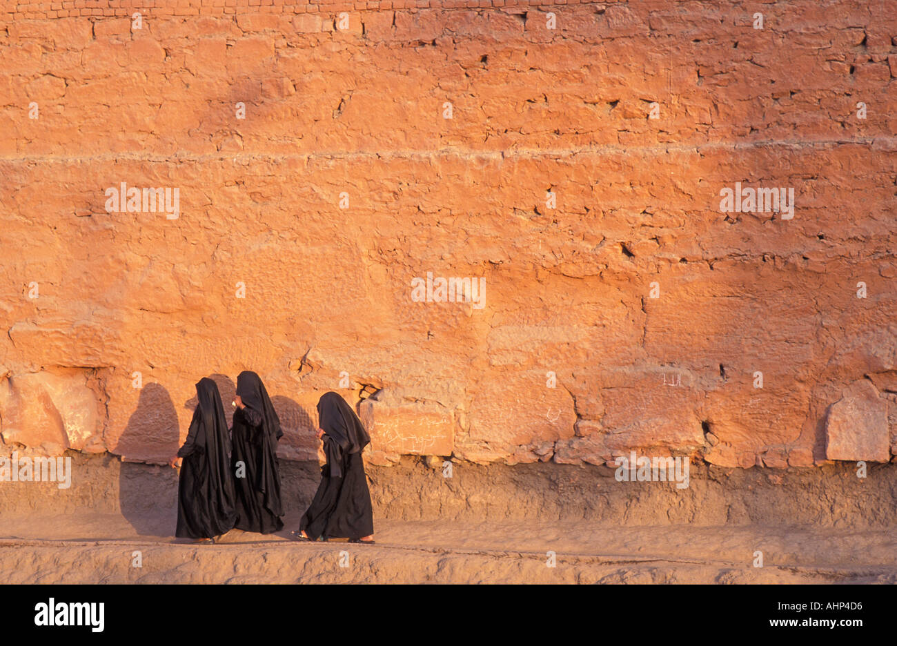 Le donne musulmane vestita di nero burqas camminando lungo la parete esterna Percorso del Tempio di Karnak Nr Luxor Egitto Foto di Jamie Marshall Foto Stock