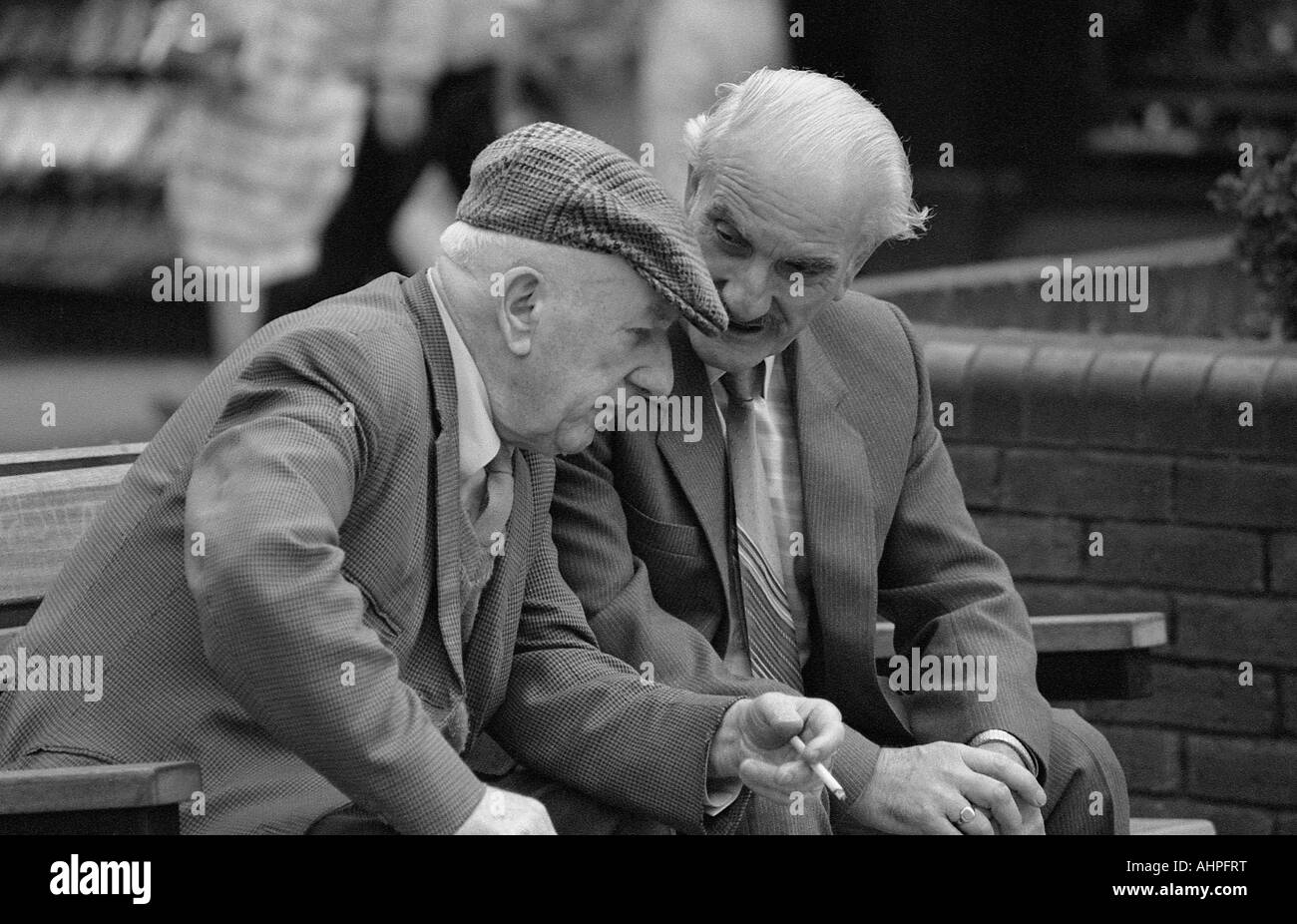 Due uomini anziani profonda discussione in seduta sul banco di lavoro. Foto Stock
