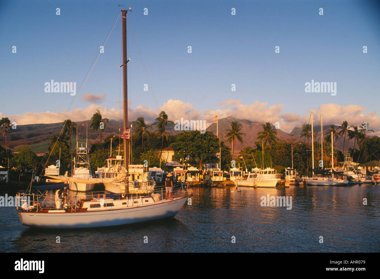 Lahaina Maui Hawaii barche a vela che entrano in porto al tramonto con montagne di West Maui dietro Foto Stock