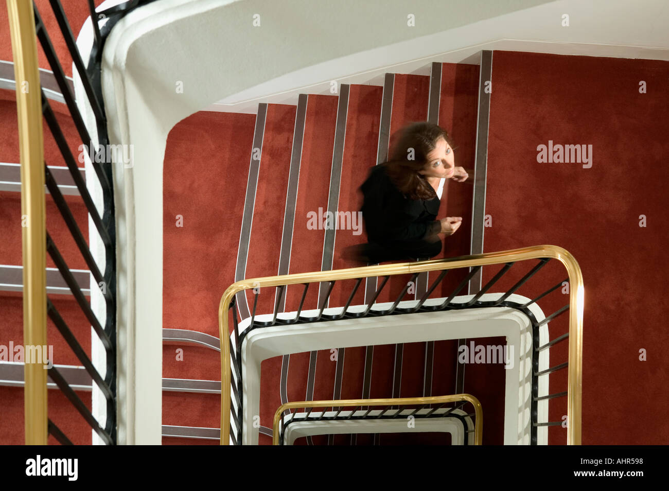 Imprenditrice a camminare su una scalinata a spirale Foto Stock