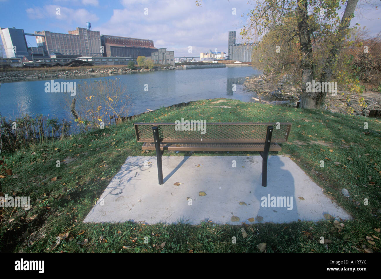 Un banco che si affaccia su un parco industriale sul Rouge River in Detroit Michigan Foto Stock