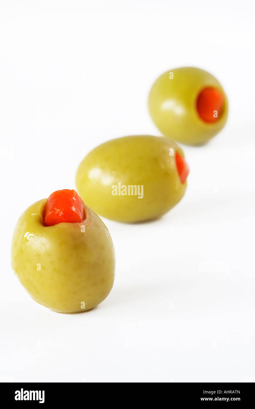 Tre olive verdi in una fila su sfondo bianco Food still life Foto Stock