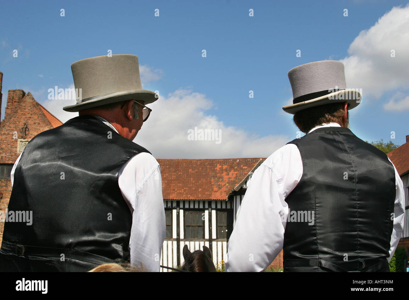 Driver e mate in top hat e code sul cavallo e carrozza aperta dando giostre per il pubblico in generale. Foto Stock