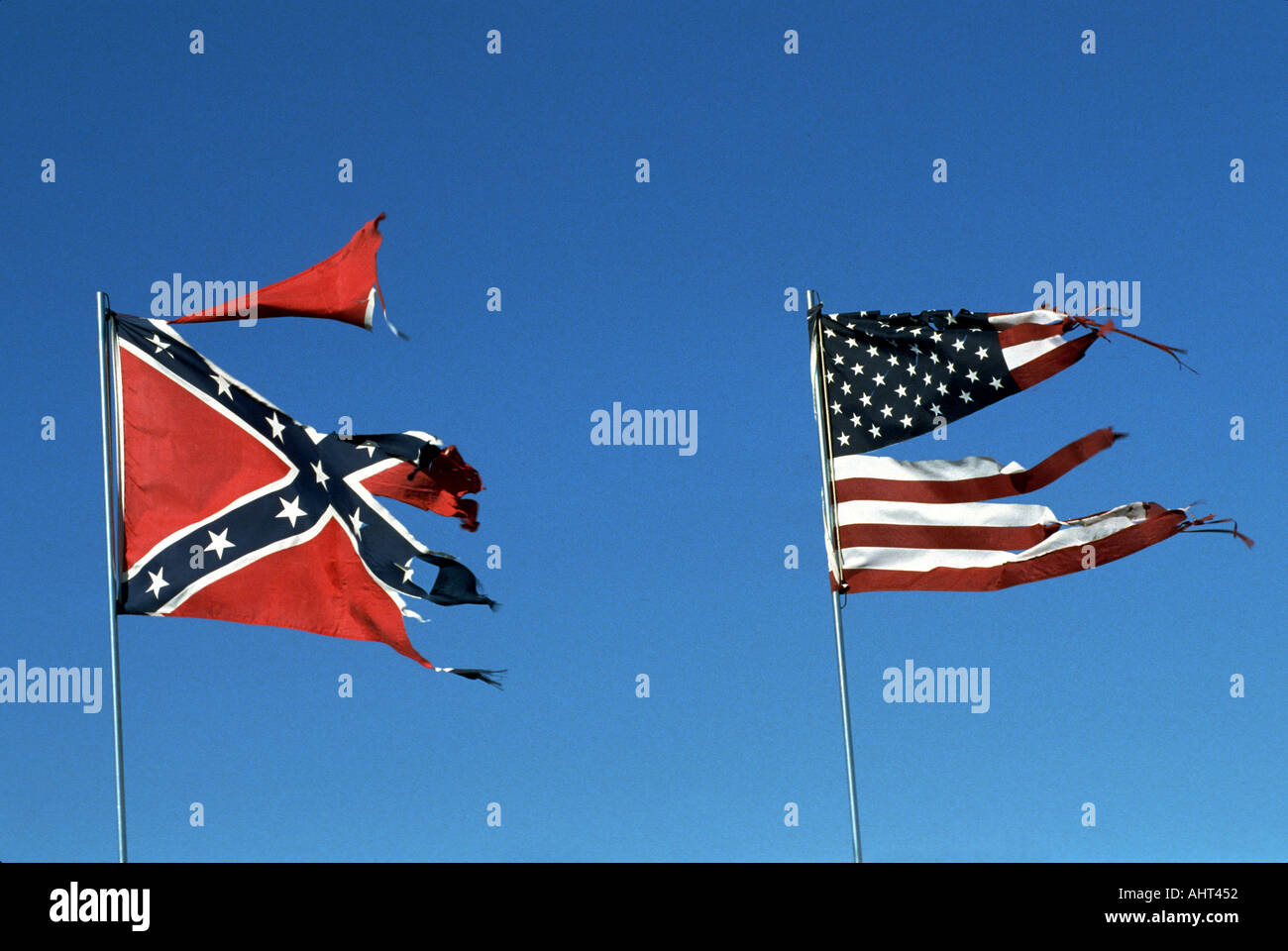 Strappato e lacerato bandiera americana vola lungo il lato meridionale bandiera confederate Foto Stock