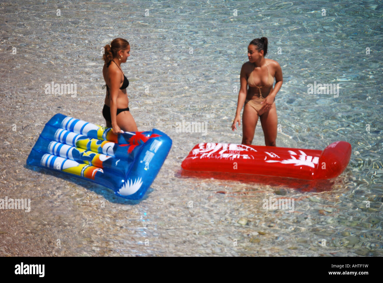 Le donne con materassini gonfiabili a bordo d'acqua, Corfu, Isole Ionie, Grecia Foto Stock