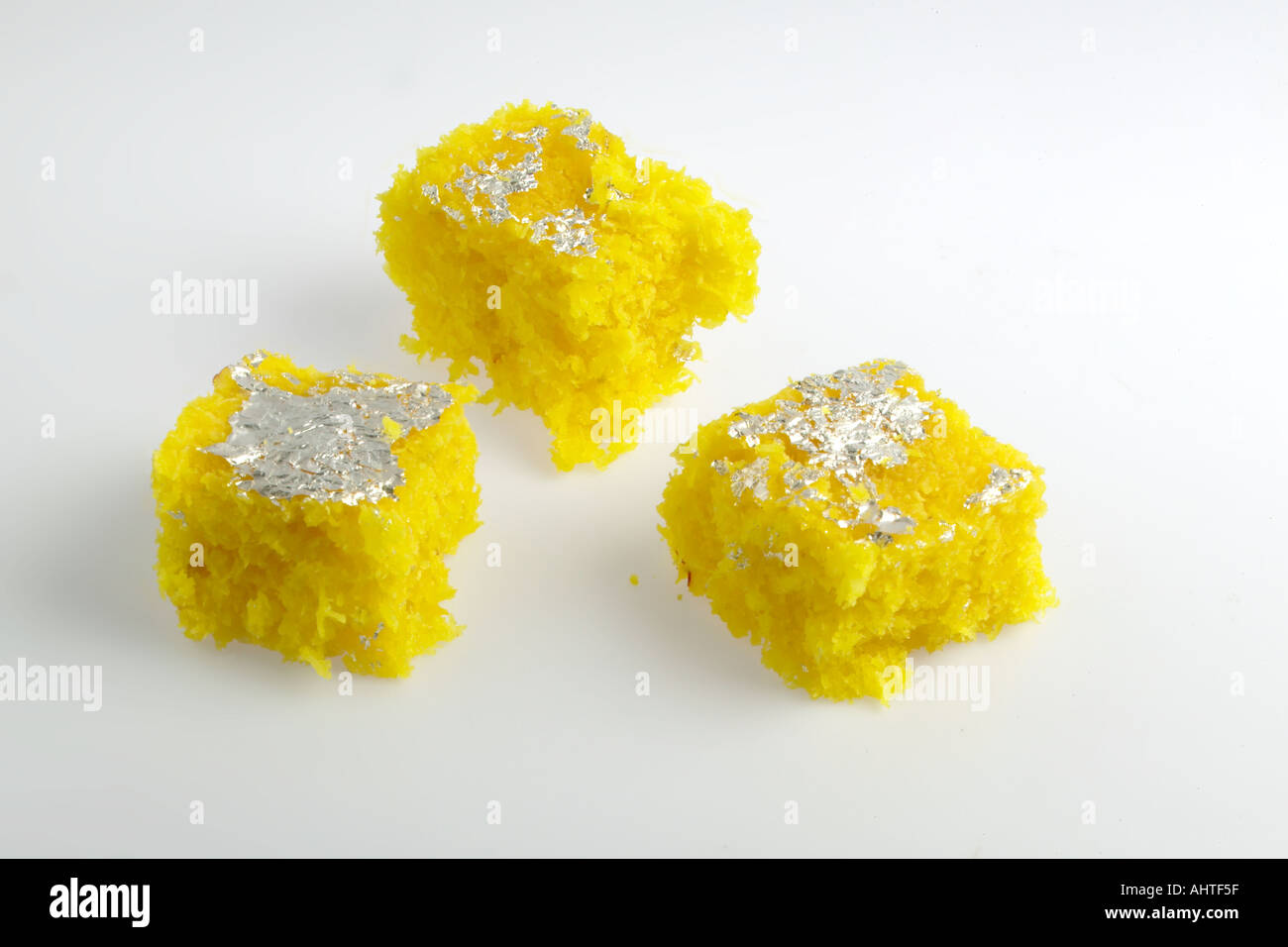 AAD91581 3 tre pezzi di Indian piatto dolce da dessert di colore giallo coprapak realizzato da noce di cocco argento topping Foto Stock