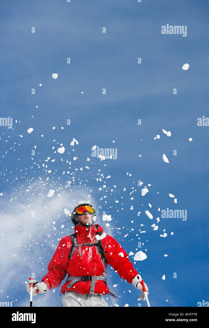 Irrorazione di neve su maschio sciatore, basso angolo di visione Foto Stock